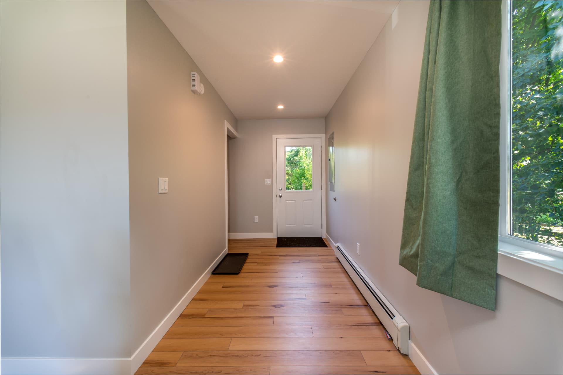 Interior hallway with wood flooring and baseboard heat