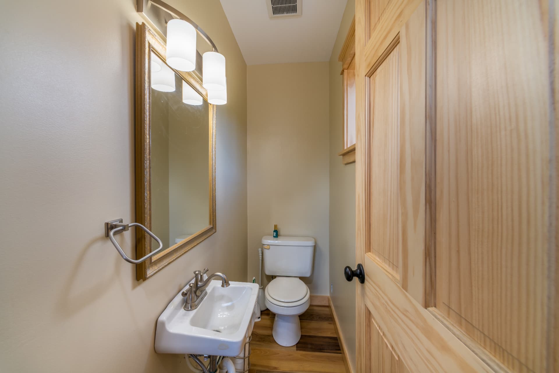 Finished half bath with pine door and wood flooring in the Ishpeming addition