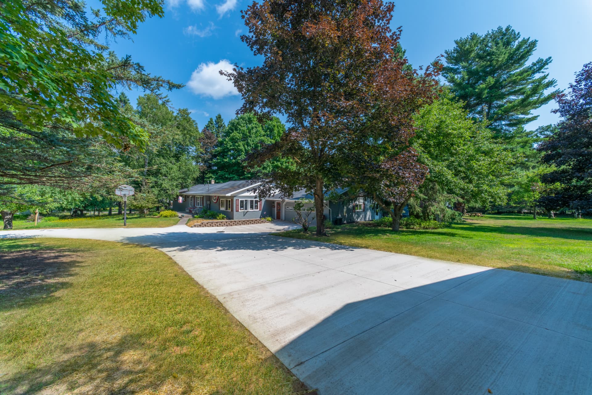 New concrete driveway and turnaround in front of a gray ranch home in Marquette County