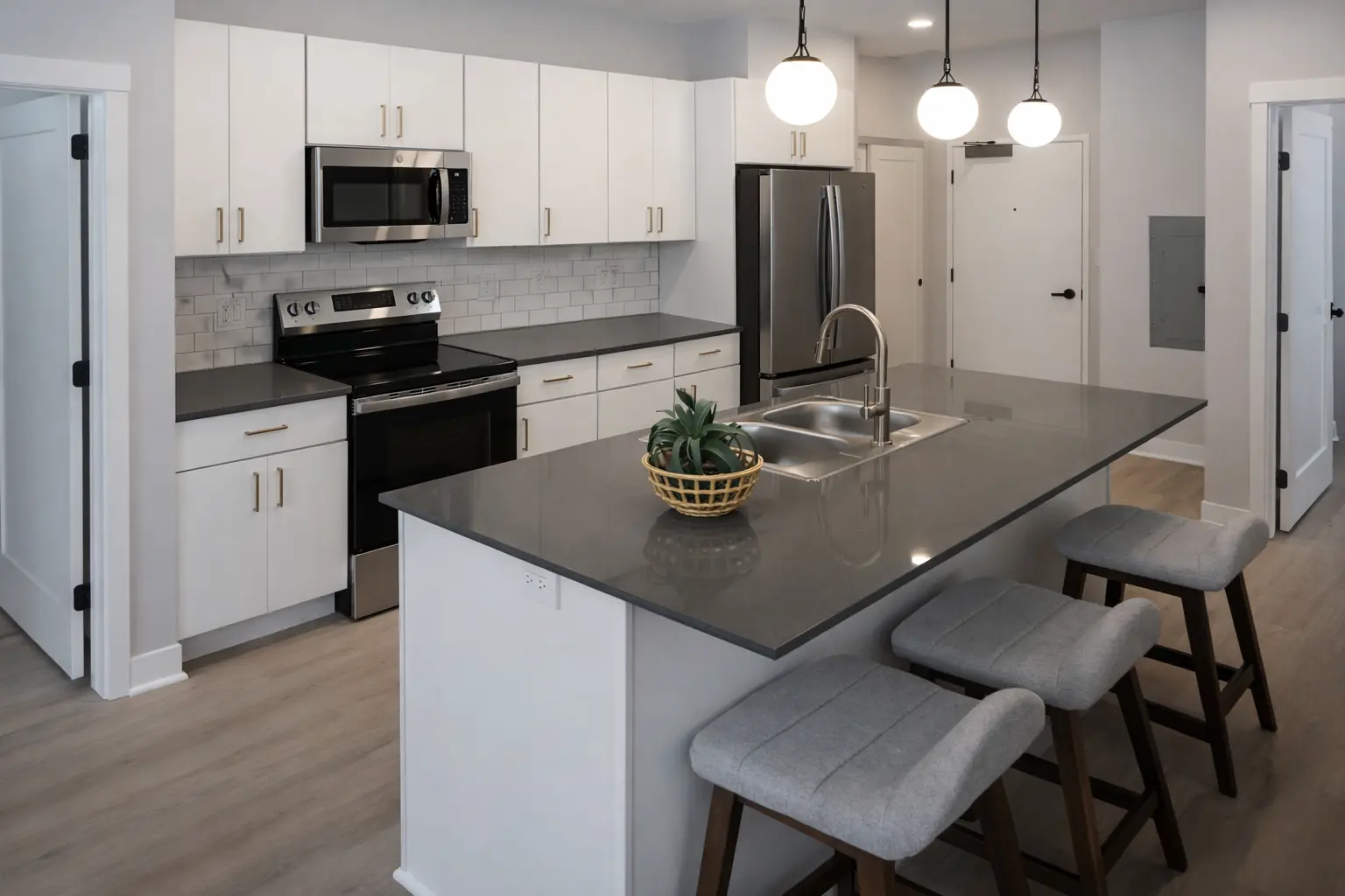 Renovated kitchen with white cabinets, quartz island, pendant lights, and modern finishes in Marquette, Michigan